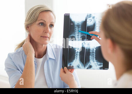 Le médecin à un de la colonne cervicale x-ray de son patient. Banque D'Images