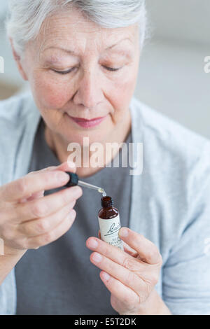 Femme à l'aide d'un remède de Bach (extrait de fleur de liquide). Banque D'Images