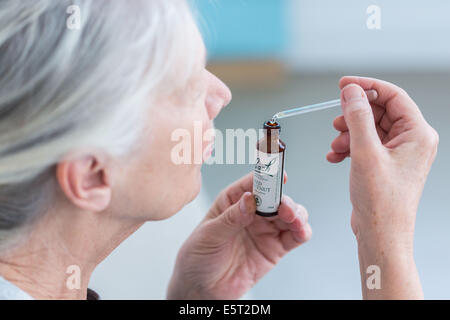 Femme à l'aide d'un remède de Bach (extrait de fleur de liquide). Banque D'Images