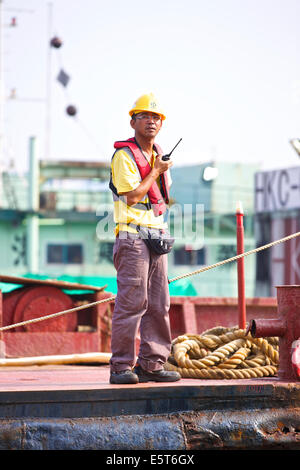 Ingénieur asiatique supervise le dragage de la Causeway Bay Typhoon Shelter, Hong Kong. Banque D'Images