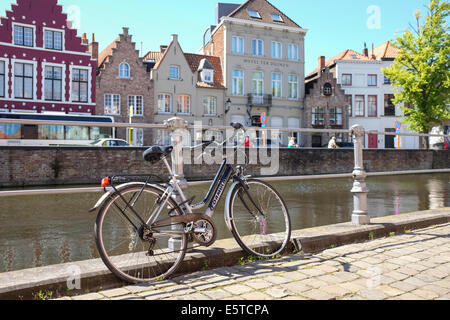 En stationnement vélo dans les rues de la vieille ville de Bruges, Belgique. Le canal et bâtiments typiques dans l'arrière-plan. Banque D'Images