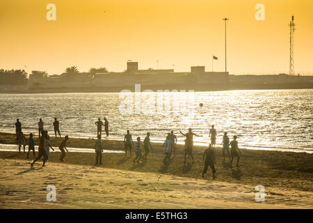 À contre-jour les hommes jouant au football sur la plage de Jomtien, Bukha, Oman, Middle East Banque D'Images