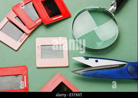 Vieux diapositives et une loupe sur table verte Banque D'Images