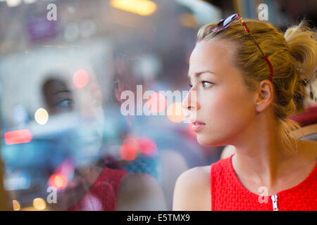 Femme regardant par la fenêtre du tramway. Banque D'Images