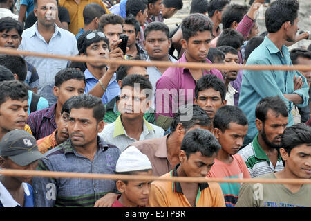 Mawa, le Bangladesh. 6e août, 2014. Les gens attendent du Bangladesh pour les corps des victimes sur le côté de la rivière Padma deux jours après l'accident de ferry dans le district de Munshiganj, quelque 37 km de la capitale Dhaka, Bangladesh, le 6 août 2014. Le bilan des morts de lundi's ferry capsizal au Bangladesh central du district de Munshiganj est passé à 11 le mercredi matin après un autre sept corps ont été extraits loin de l'endroit où le navire a coulé avec environ 250 passagers à bord, a annoncé la police. Shariful Islam Crédit :/Xinhua/Alamy Live News Banque D'Images