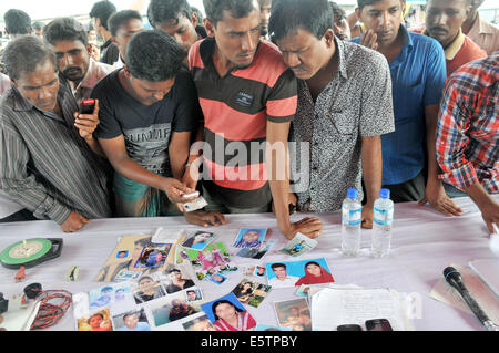 Mawa, le Bangladesh. 6e août, 2014. Des proches de victimes montrent des photos de leurs proches disparus deux jours après l'accident de ferry dans le district de Munshiganj, quelque 37 km de la capitale Dhaka, Bangladesh, le 6 août 2014. Le bilan des morts de lundi's ferry capsizal au Bangladesh central du district de Munshiganj est passé à 11 le mercredi matin après un autre sept corps ont été extraits loin de l'endroit où le navire a coulé avec environ 250 passagers à bord, a annoncé la police. Shariful Islam Crédit :/Xinhua/Alamy Live News Banque D'Images