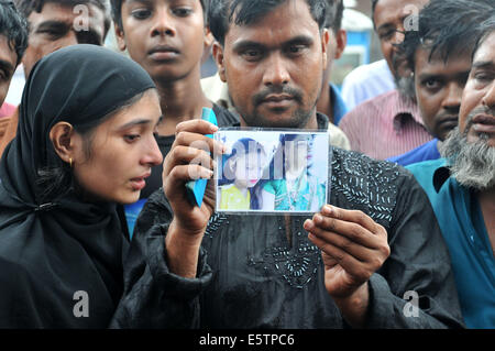 Mawa, le Bangladesh. 6e août, 2014. Des proches de victimes montrent des photos de leurs proches disparus deux jours après l'accident de ferry dans le district de Munshiganj, quelque 37 km de la capitale Dhaka, Bangladesh, le 6 août 2014. Le bilan des morts de lundi's ferry capsizal au Bangladesh central du district de Munshiganj est passé à 11 le mercredi matin après un autre sept corps ont été extraits loin de l'endroit où le navire a coulé avec environ 250 passagers à bord, a annoncé la police. Shariful Islam Crédit :/Xinhua/Alamy Live News Banque D'Images