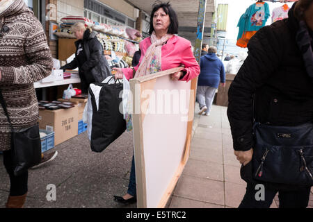 Femme transportant grande toile imprimer acheté au marché intérieur Banque D'Images