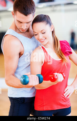 Deux smiling people working out with dumbbells Banque D'Images