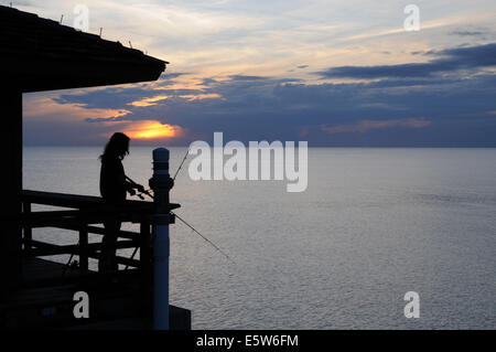 Un pêcheur solitaire tente sa chance au coucher du soleil de Naples Pier, Floride Banque D'Images