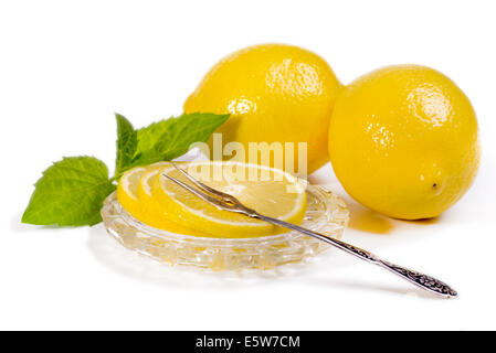 Citrons - tranches et fruits sur une soucoupe de cristal, vintage pour les citrons de la fourche. Isolé sur fond blanc Banque D'Images