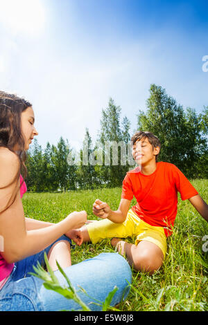 Les jeux des enfants roche-papier-ciseaux sur l'herbe Banque D'Images