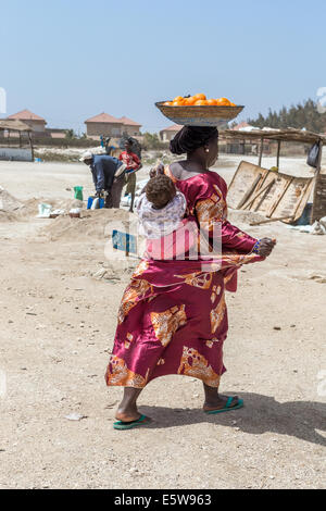 Femme avec bébé portant des fruits sur la tête, Lac Rose aka Lac Retba, Lac Rose, Sénégal Banque D'Images