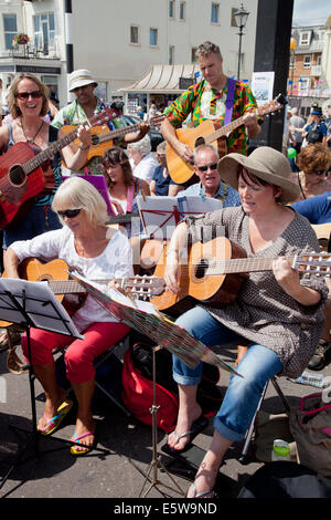 La ville de Sidmouth, Devon, UK. 6e août, 2014. La musique et la danse à l'assemblée annuelle de la semaine folklorique à Sidmouth. Des groupes de guitare Exeter guitare divertir les visiteurs massés sur la promenade de Sidmouth. Crédit : Anthony Collins/Alamy Live News Banque D'Images