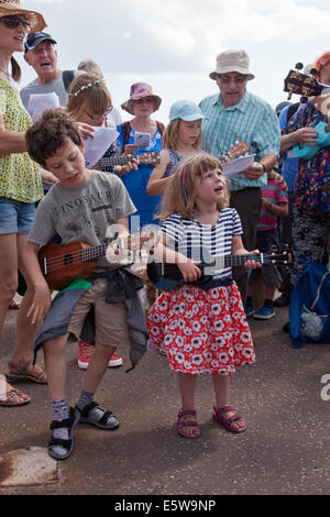 La ville de Sidmouth, Devon, UK. 6e août, 2014. La musique et la danse à l'assemblée annuelle de la semaine folklorique à Sidmouth. Les jeunes joueurs dans un groupe ukulele accompagnement musical de fournir un exposé sur la géologie de la Côte Jurassique, Sidmouth Crédit : Anthony Collins/Alamy Live News Banque D'Images