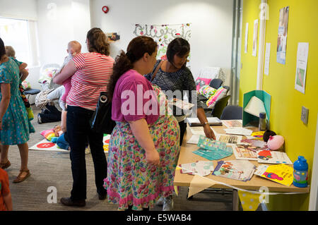Milton Keynes, Royaume-Uni, 6e août 2014. Regarder les femmes de dépliants à l'occasion du lancement du café pendant l'allaitement de Milton Keynes la Semaine mondiale de l'allaitement maternel. Crédit : David Isaacson/Alamy Live News Banque D'Images