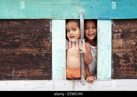 Portrait of happy smiling children batak, du trou de la maison batak traditionnel sur l'île de samosir au lac toba Batak Toba enfants curieux. Banque D'Images