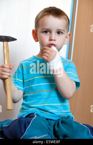 Blessé à la main gauche avec bandage garçon à tourné en home Banque D'Images