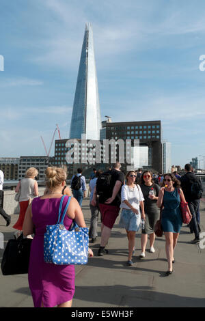 Ville de Londres, les employés de bureau à pied à travers le pont de Londres après le travail en été après le travail et le gratte-ciel Shard London UK KATHY DEWITT Banque D'Images