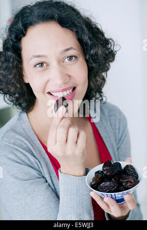 Woman eating fruit séché Banque D'Images