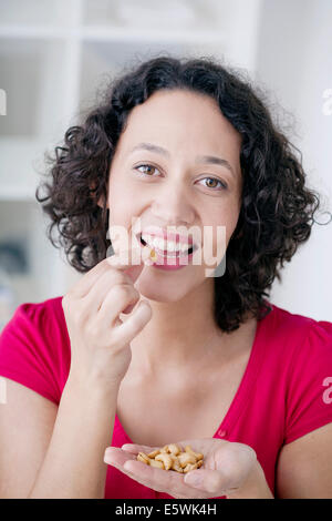 Woman eating fruit séché Banque D'Images