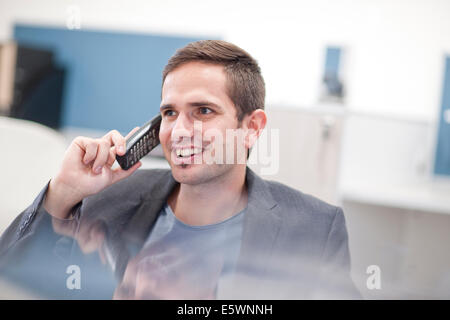 Male office worker sur téléphone fixe Banque D'Images