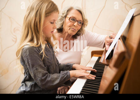 Grand-mère petite-fille d'enseignement piano Banque D'Images