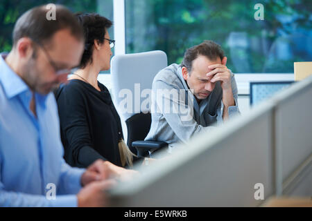 Businesspeople sitting at desk travailler Banque D'Images