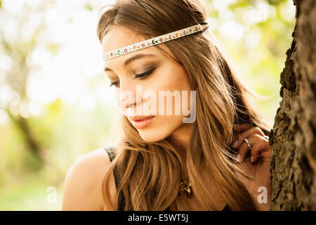 Young woman wearing headband, regardant vers le bas Banque D'Images