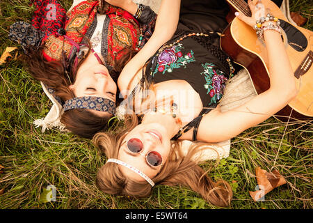 Filles Hippy lying in field with guitar Banque D'Images