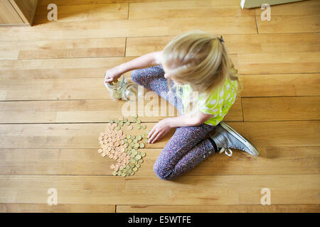 Girl à compter des pièces de savings jar Banque D'Images