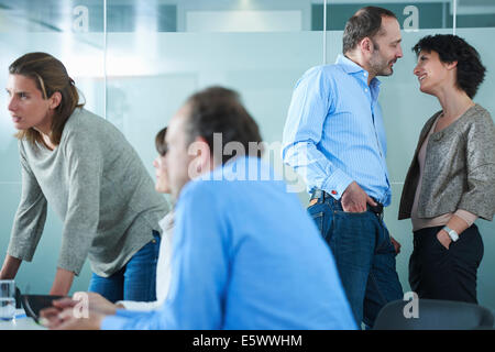 Les hommes et femmes rencontrer et de parler de manière informelle au bureau Banque D'Images