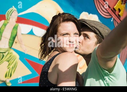 Young couple taking self portrait at fête foraine Banque D'Images