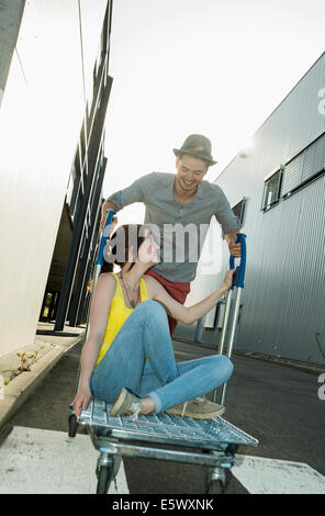 Jeune couple couchait sur panier dans Street Banque D'Images