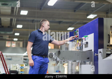 À l'aide de travailleurs dans l'usine d'emballage de papier de la machine Banque D'Images