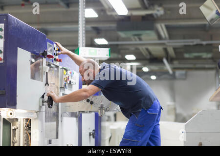 À l'aide de travailleurs dans l'usine d'emballage de papier de la machine Banque D'Images