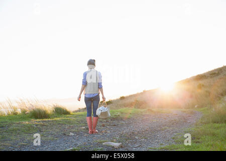 Young woman standing on hill au coucher du soleil Banque D'Images