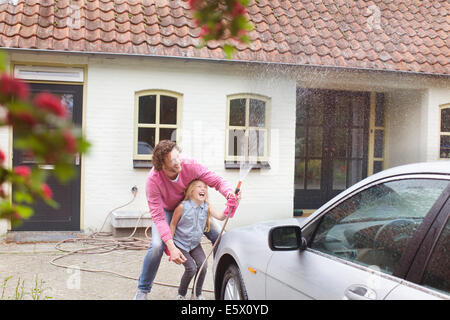 Girl aider père laver sa voiture Banque D'Images