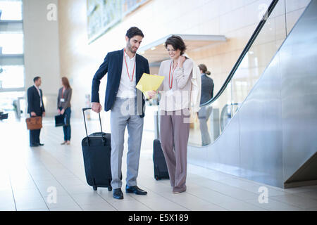 Businessman and businesswoman arrivant dans l'atrium du centre de conférence Banque D'Images