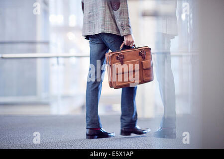 Cropped shot of young businessman with briefcase in conference centre Banque D'Images