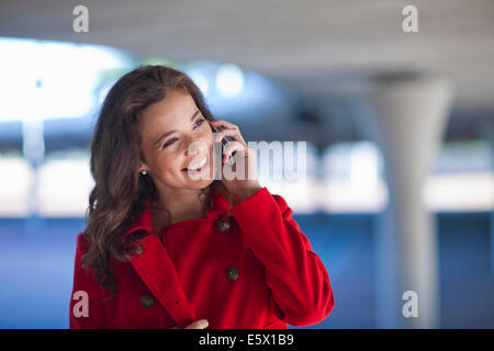 Young woman chatting on smartphone dans le passage souterrain de la ville Banque D'Images