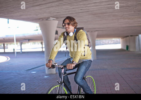 Mid adult man du vélo à travers le passage souterrain de la ville Banque D'Images