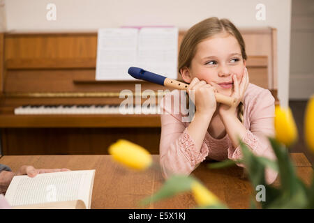 Ennuyer distrait girl avec enregistreur Instrument en salle à manger Banque D'Images