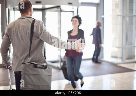 Jeune homme d'armes d'ouverture pour l'amie de conference center atrium Banque D'Images