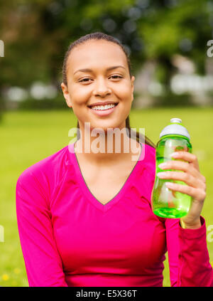 Smiling teenage girl montrant bouteille Banque D'Images