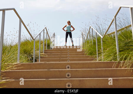 Femme debout du haut des escaliers Banque D'Images