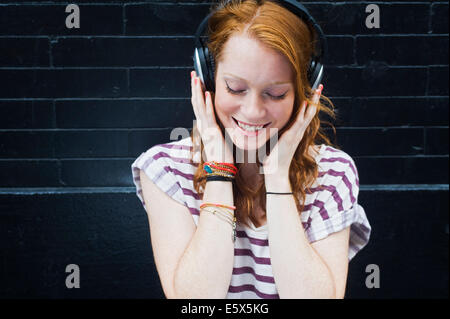 Portrait of young woman wearing headphones Banque D'Images