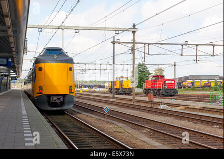 Yellow train de voyageurs à la gare de plate-forme vide Banque D'Images