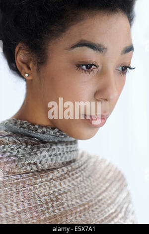 Portrait close up studio portrait of beautiful young woman gazing down Banque D'Images