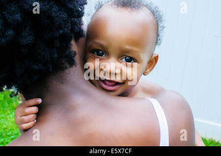 Close up portrait of baby boy à la recherche sur l'épaule de la mère Banque D'Images